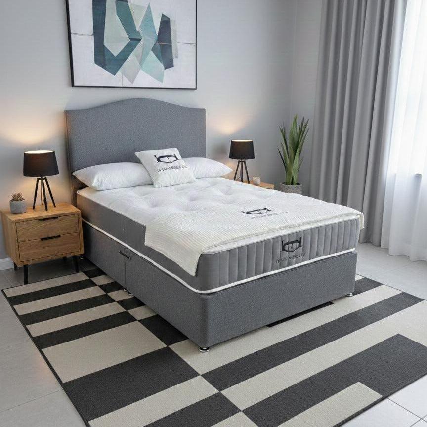 Modern bedroom with gray bed, striped rug, and abstract art on the wall.