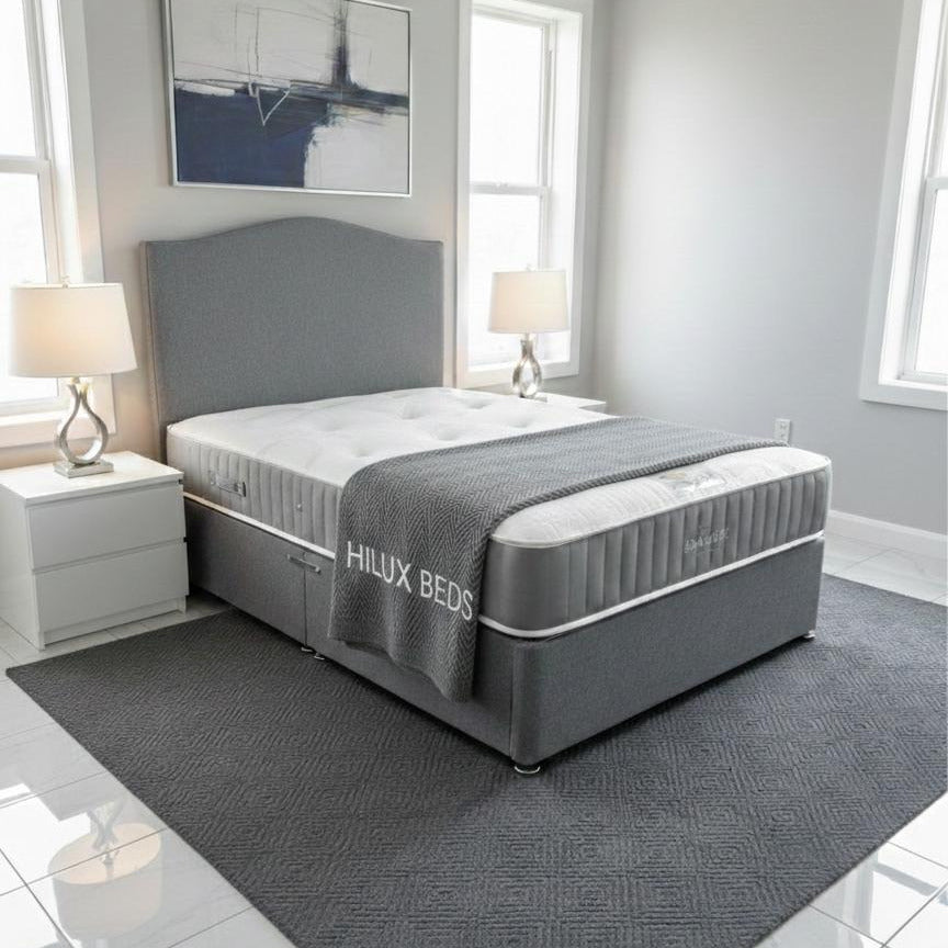 Gray bed with 'Hilux Beds' branding in a modern bedroom setting.