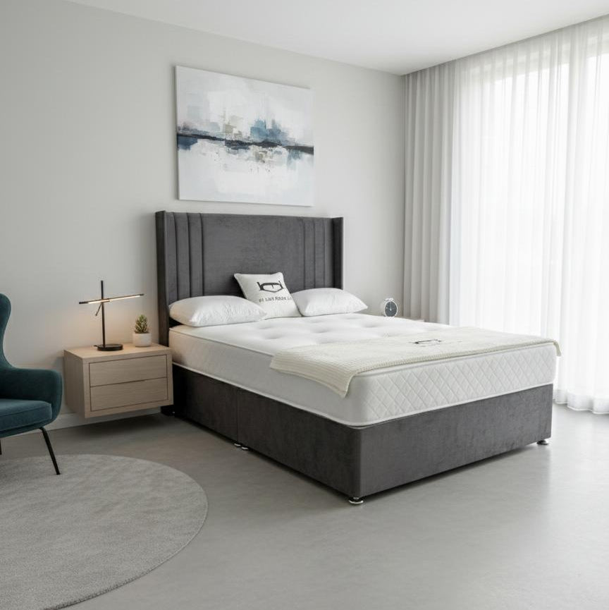 Modern bedroom with a gray upholstered bed and white bedding.
