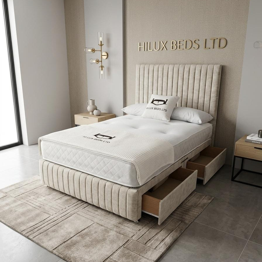Beige upholstered bed with storage drawers in a modern bedroom setting, featuring the Hilux Beds Ltd logo.
