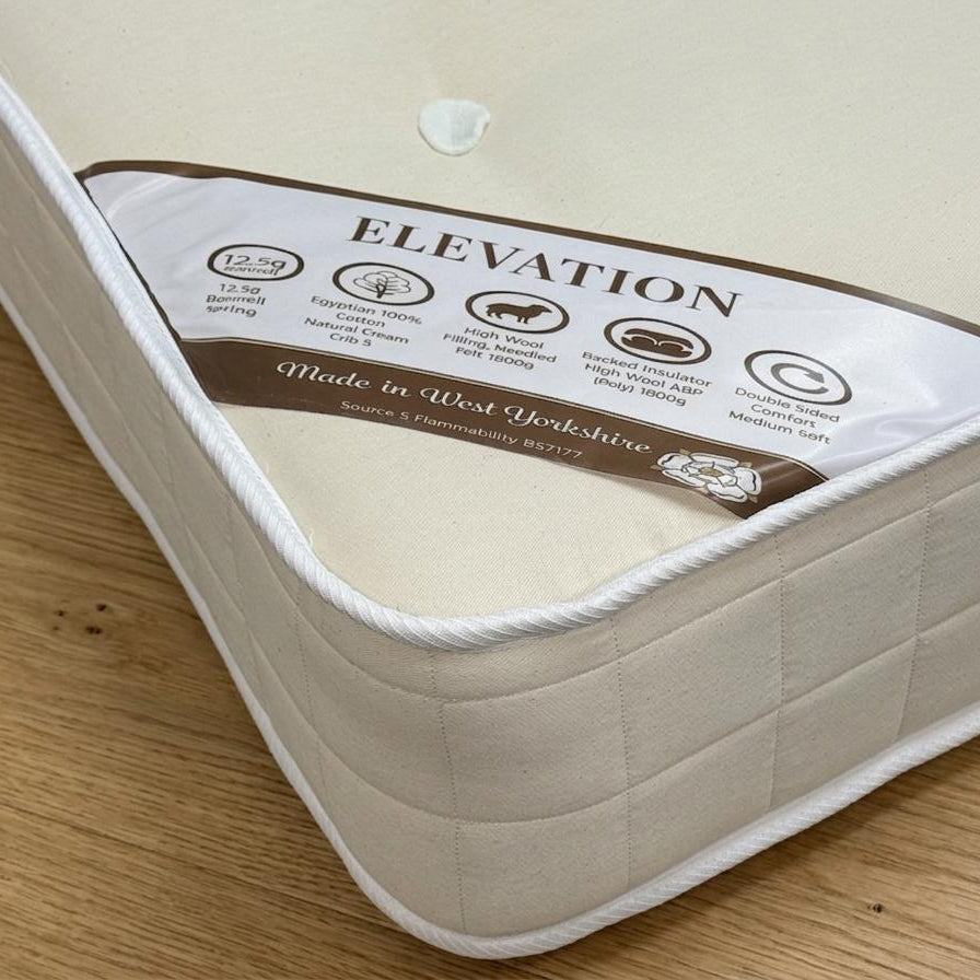Mattress with 'Elevation' brand label on a wooden floor