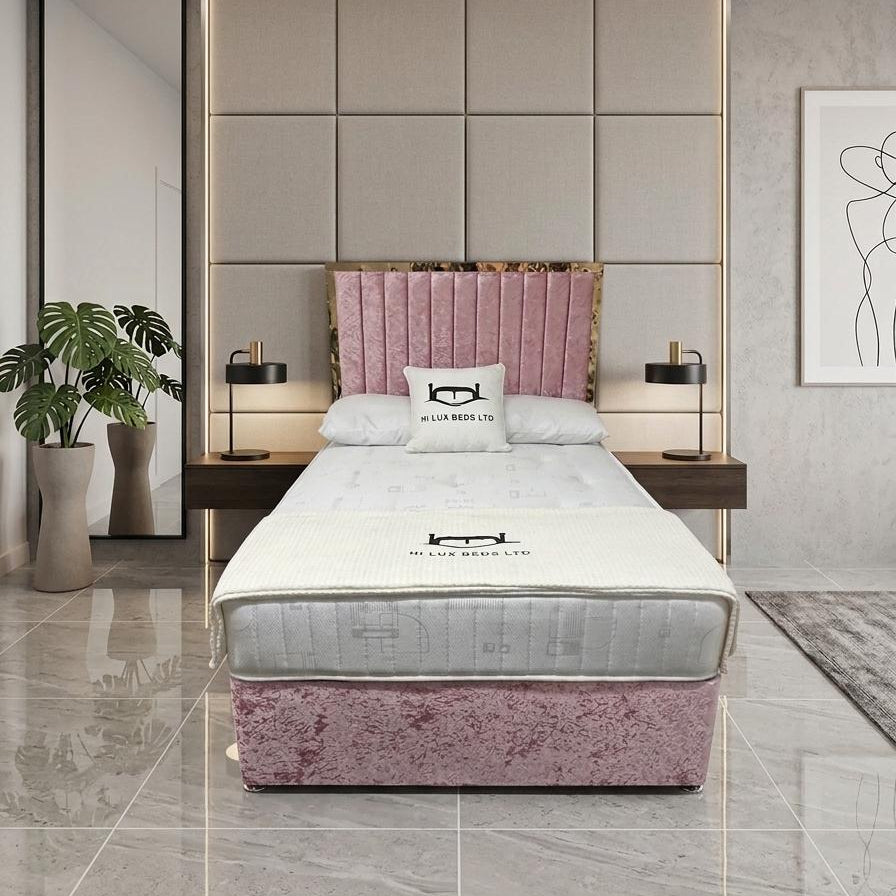 Modern bedroom with pink headboard and matching footboard, featuring a bed and nightstands.