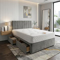 Modern bedroom with a gray upholstered bed and wooden side tables.