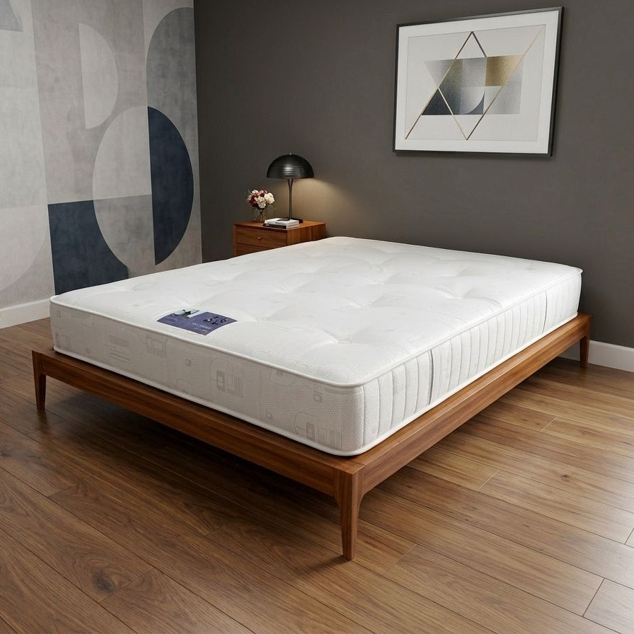 Mattress on a wooden bed frame in a room with abstract wall art and a lamp.