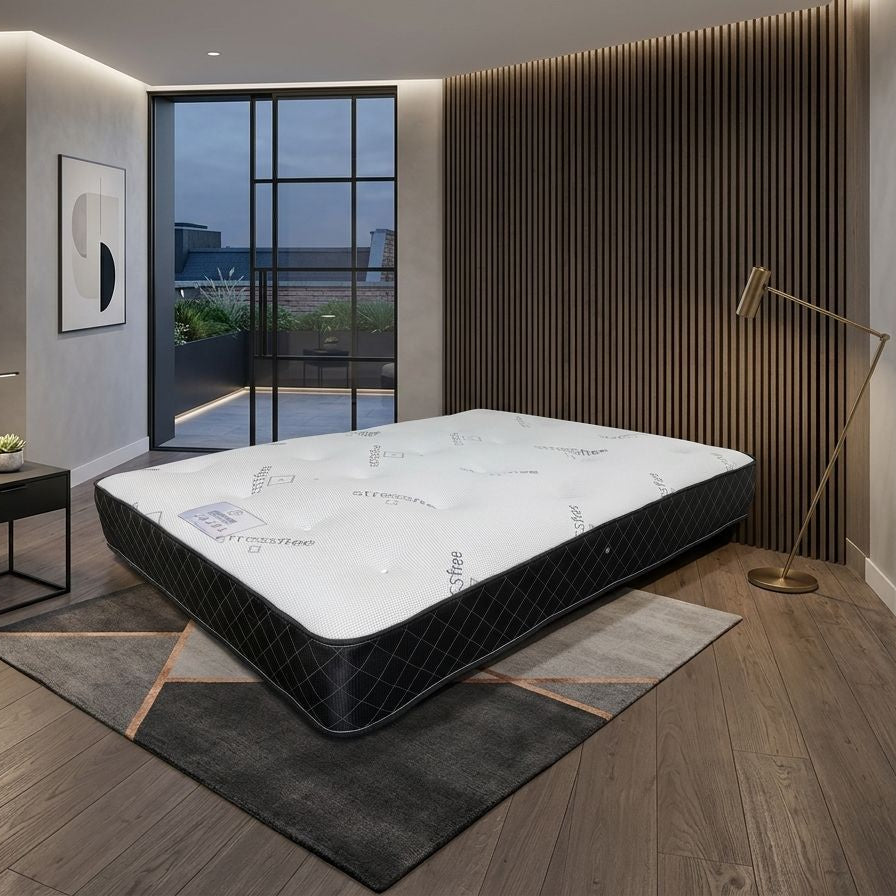 Mattress displayed in a modern bedroom with wooden flooring and large windows.