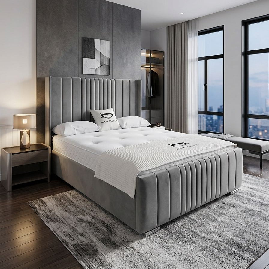 Modern bedroom with gray upholstered bed, nightstands, and large windows.