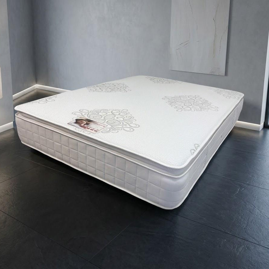 White mattress on a dark wooden floor with a cityscape view in the background