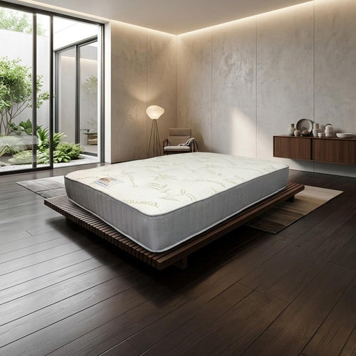 Modern bedroom with a mattress on a wooden bed frame, large windows, and minimal decor.