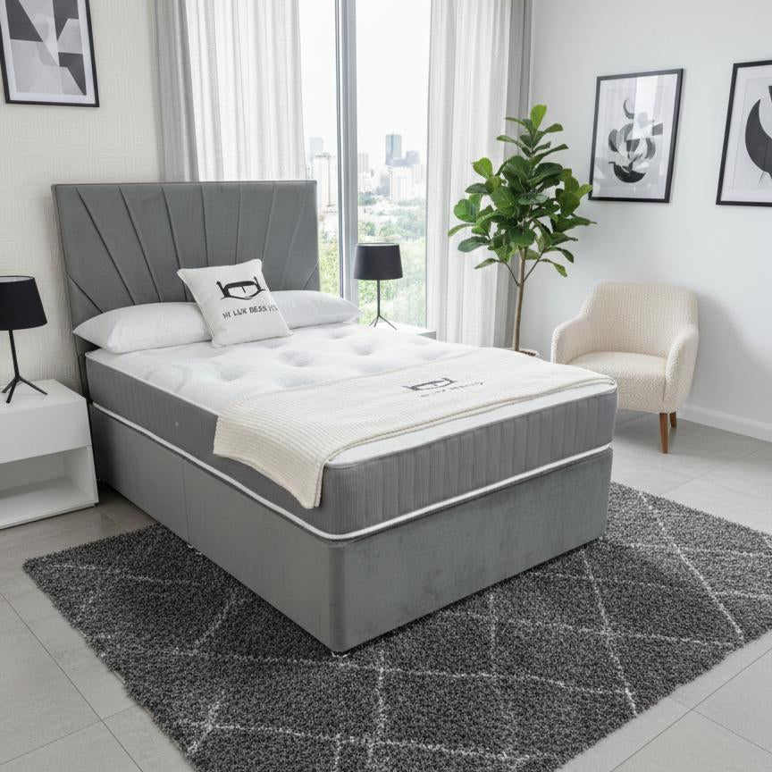 Gray bed with white mattress in a modern bedroom setting