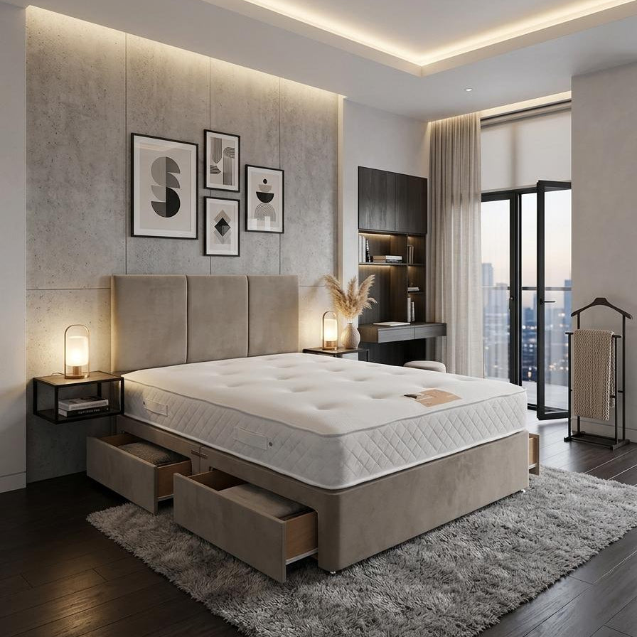 A modern bedroom featuring a low-profile platform bed with a tufted white mattress and built-in storage drawers underneath, set on a gray shag rug. The background wall has a textured light gray panel with three framed abstract prints and recessed LED lighting.