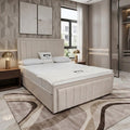 A modern bedroom featuring a beige upholstered bed frame with a white mattress, styled with neutral-toned bedding, a matching patterned area rug, and contemporary wall decor.